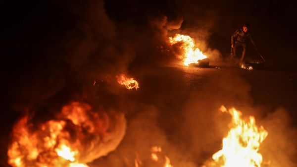 Palestinian youth react as they burn tires during a protest on the streets of Gaza City on April 5, 2023. - Sputnik International