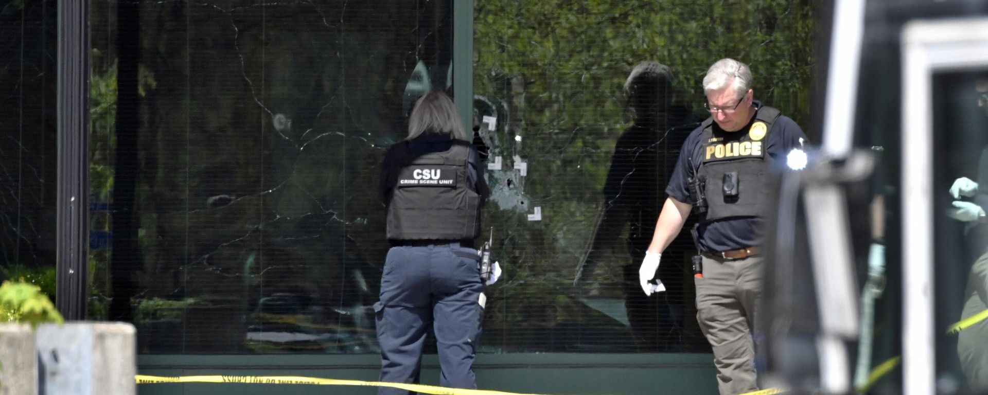A Louisville Metro Police crime scene technician photographs bullet holes in the glass of the Old National Bank building in Louisville, Ky., Monday, April 10, 2023. A shooting at the bank killed and wounded several people police said. The suspected shooter was also dead. - Sputnik International, 1920, 11.04.2023