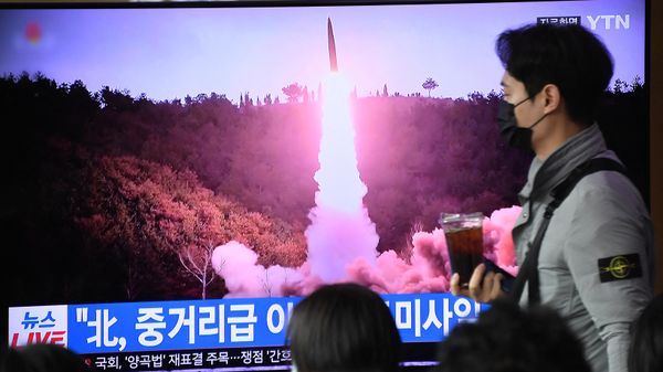A man walks past a television screen showing a news broadcast with file footage of a North Korean missile test, at a railway station in Seoul on April 13, 2023 - Sputnik International