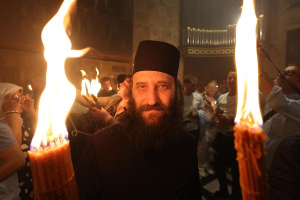 Orthodox Christians gather with lit candles during the Holy Fire ceremony at the Holy Sepulcher church in Jerusalem's Old City on April 15, 2023 on the eve of Easter Sunday. - Sputnik International