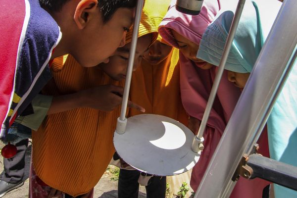 Children glimpse at the solar eclipse reflected on the base of a telescope in Yogyakarta, Indonesia. Those who were lucky enough either saw the darkness of the total eclipse or the “ring of fire” as the sun peered out from behind the new moon. - Sputnik International