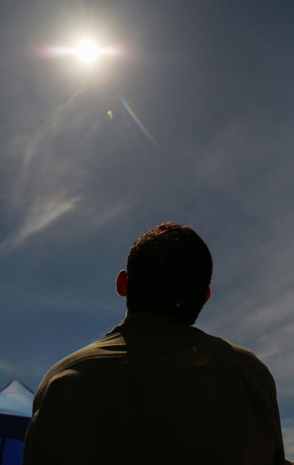 Hybrid solar eclipses are rare and occur about once every 18 months.Above: People watch a solar eclipse using special glasses in Dili. - Sputnik International