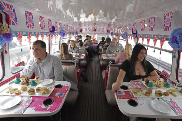 Tourists sit on a Coronation Tour Bus, in London. The May 6 coronation is luring royal fans and far-flung visitors fascinated by the ceremonial spectacle — and drama — of the monarchy and eager to experience a piece of British history. Tour companies, shops and restaurants are rolling out the red carpet, whether it's a decked-out bus tour of London's top sights boasting high tea or merchandise running from regal to tat.  - Sputnik International