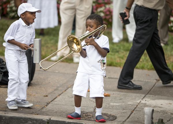 Youngsters raised in the traditional music of the Southern "shout bands" mirror the music of their elders as believers gather on Memorial Day weekend. Inspired by jazz, gospel, and Dixieland, the pulsing trombones gradually intensify their call, bringing hundreds of worshipers to their feet while firehoses provide a spiritual soaking outside the church.  - Sputnik International