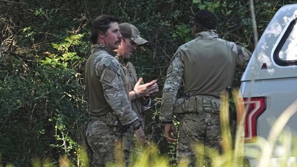 Law enforcement officers wait at the end of a road after a possible shooting suspect sighting, Monday, May 1, 2023, near Conroe, Texas. The search for a Texas man who allegedly shot his neighbors after they asked him to stop firing off rounds in his yard stretched into a third day Monday. - Sputnik International