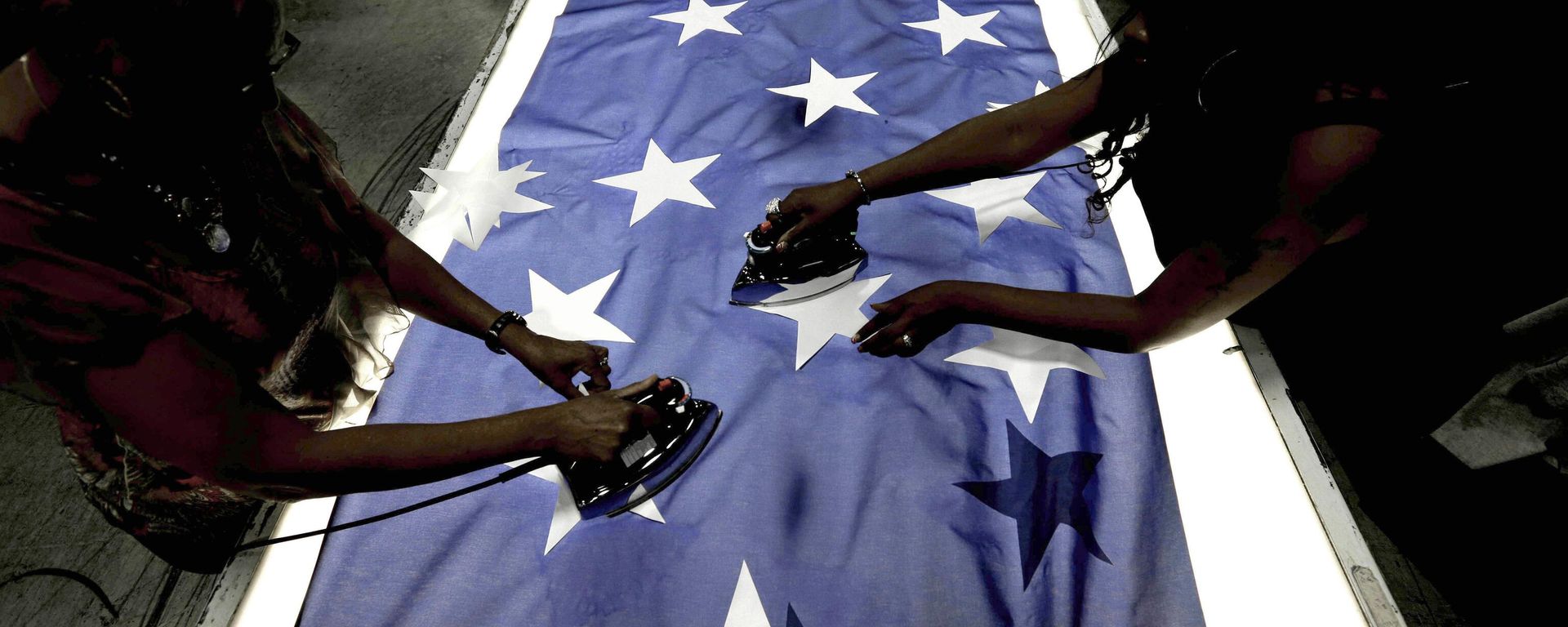 Employees Lottie Penick, left, and Melissa Hodnett iron stars onto a United States flag at Annin Flagmakers in South Boston, Va. File photo. - Sputnik International, 1920, 06.05.2023