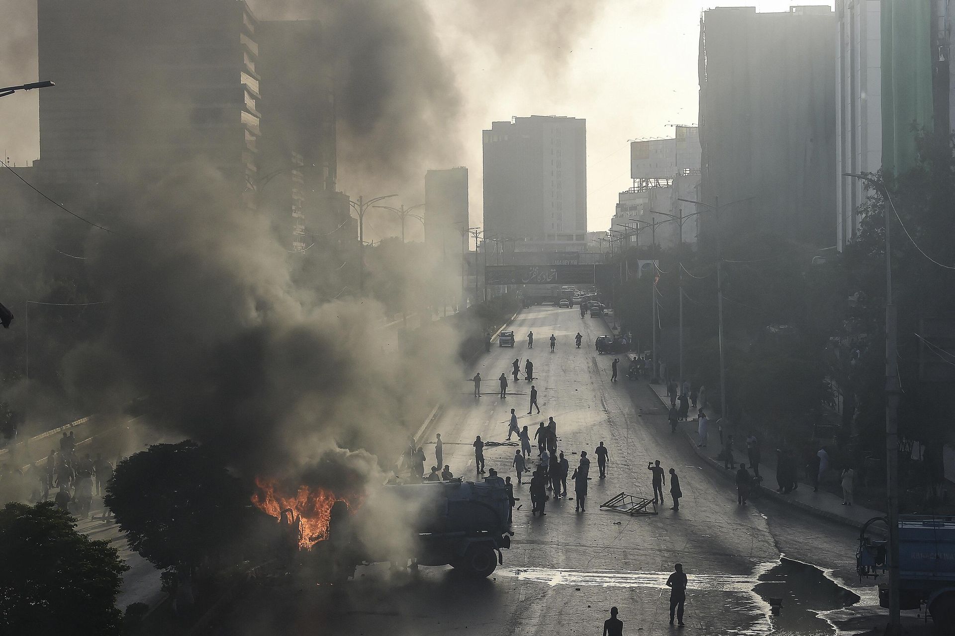 Pakistan Tehreek-e-Insaf (PTI) party activists and supporters of former Pakistan's Prime Minister Imran gather beside burning water tanker on a block road during a protest against the arrest of their leader in Karachi on May 9, 2023 - Sputnik International, 1920, 10.05.2023