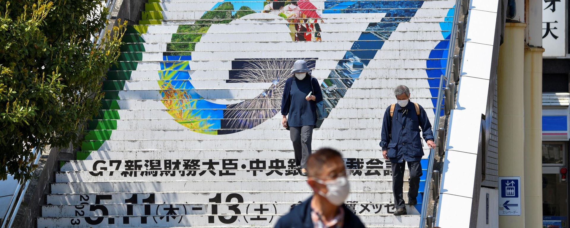 People walk down stairs displaying the logo of the upcoming G7 Finance Ministers and Central Bank Governors' Meeting at Niigata railway station in Niigata on May 10, 2023 - Sputnik International, 1920, 11.05.2023