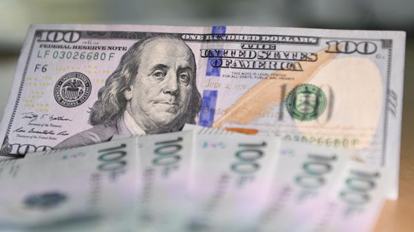 Picture of a one hundred US dollar bill next to Colombian one hundred thousand peso bills taken in Bogota, on October 24, 2022 - Sputnik International