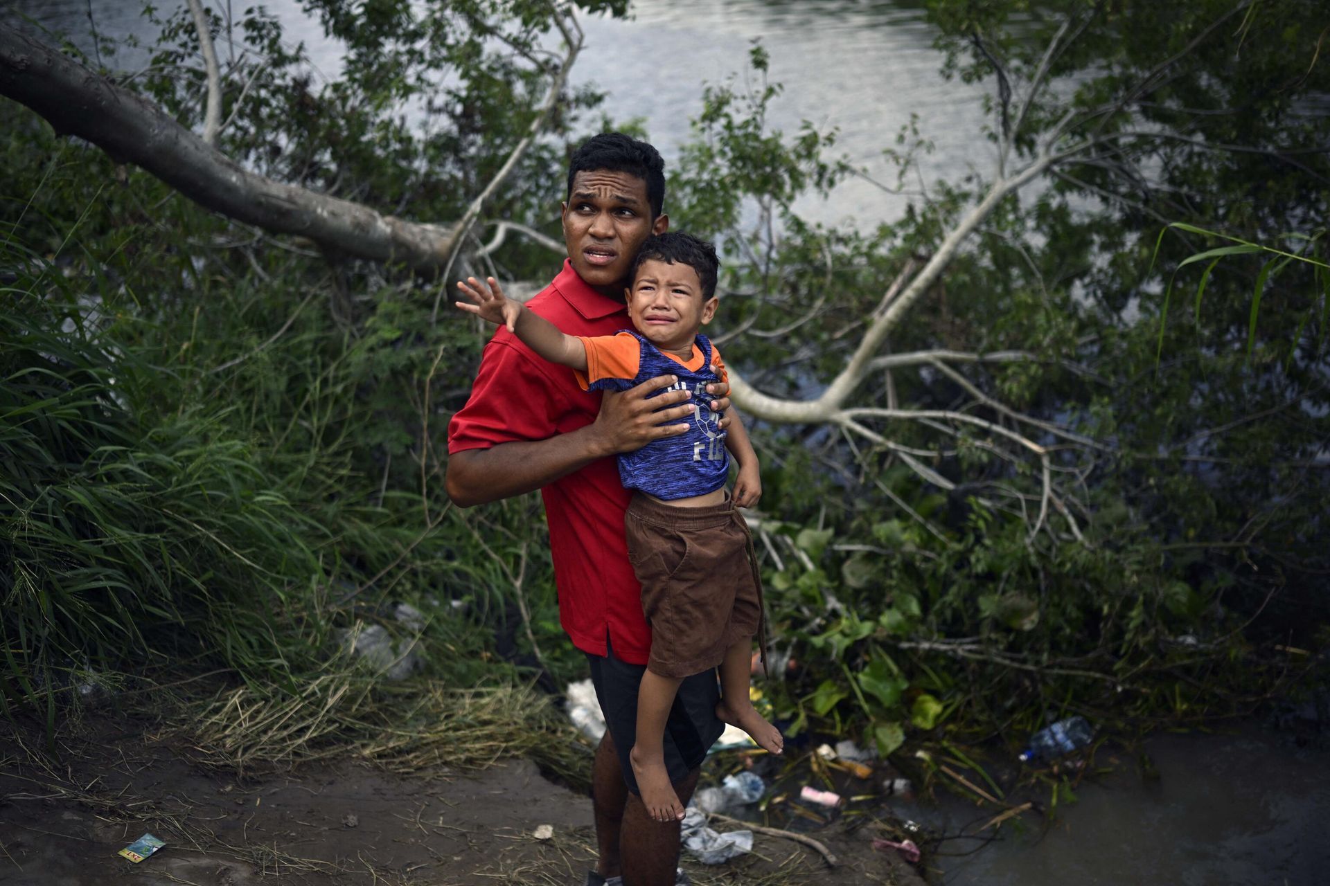 A migrant carrying a child tries to get to the US through the Rio Grande River as seen from Matamoros, state of Tamaulipas, Mexico, on May 11, 2023. - Sputnik International, 1920, 14.05.2023