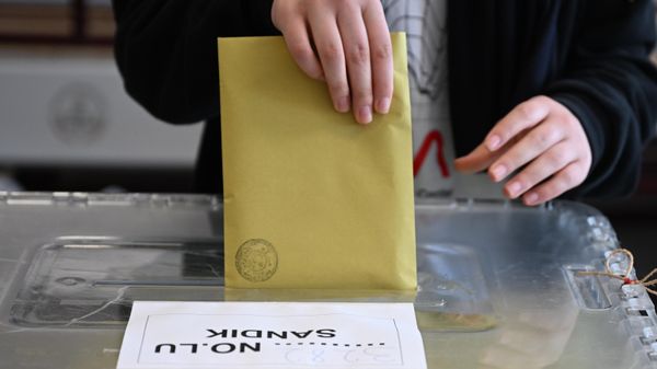 A voter drops the ballots into the ballot box at the polling station during the presidential and parliamentary elections A voter drops the ballots into the ballot box at the polling station during the presidential and parliamentary elections - Sputnik International