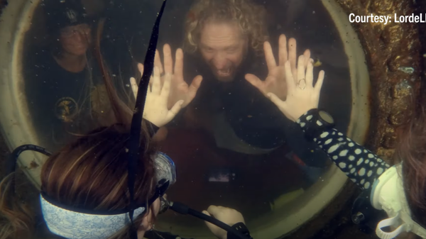 Dituri exploring the ocean with visiting scientists and interacting with divers from his underwater habitat's window. - Sputnik International