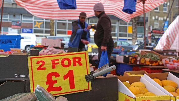 A sign displays the price in pound sterling of food goods, including cucumbers, at a a fruit and vegetable market in stall east London on March 31, 2023 - Sputnik International