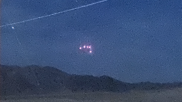 A purported UFO spotted over Marine Corps Air Ground Combat Center Twentynine Palms in April 2021. The photo, taken on a low-light camera, purports to have captured the UFO's triangular shape. - Sputnik International