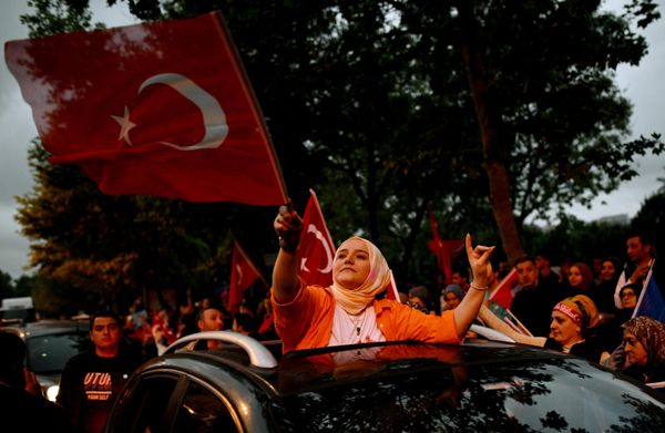 A supporter of incumbent President Recep Tayyip Erdogan carrying a flag in front of the office of the ruling party in Istanbul. - Sputnik International