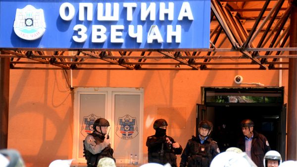 Kosovo riot police along with KFOR military police, secure access to a municipal building in Zvecan as Kosovo Serbs gather outside the building after police helped install ethnic Albanian mayors following controversial elections.  - Sputnik International