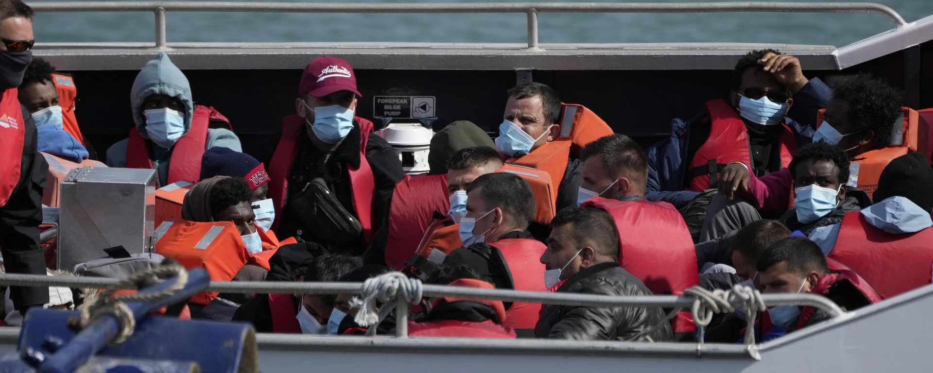 People thought to be migrants who undertook the crossing from France in small boats and were picked up in the Channel, wait to be disembarked from a British border force vessel, in Dover, south east England People thought to be migrants who undertook the crossing from France in small boats and were picked up in the Channel, wait to be disembarked from a British border force vessel, in Dover, south east England - Sputnik International, 1920, 05.12.2023