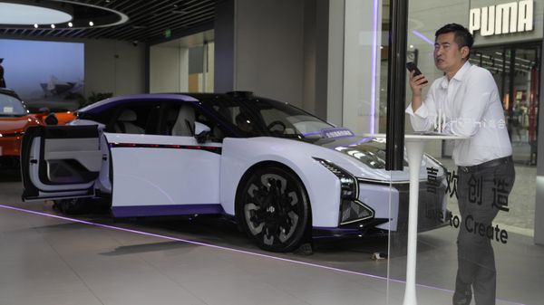 A man talks on his phone near an electric car from Chinese automaker HiPhi at a showroom in Beijing, Thursday, April 13, 2023. Global and Chinese automakers plan to unveil more than a dozen new electric SUVs, sedans and muscle cars this week at the Shanghai auto show, their first full-scale sales event in four years in a market that has become a workshop for developing electrics, self-driving cars and other technology. - Sputnik International