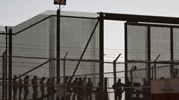 Migrants wait along the border wall at gate 42 to surrender to US Customs and Border Protection (CBP) Border Patrol agents for immigration and asylum claim processing on May 11, 2023.  - Sputnik International