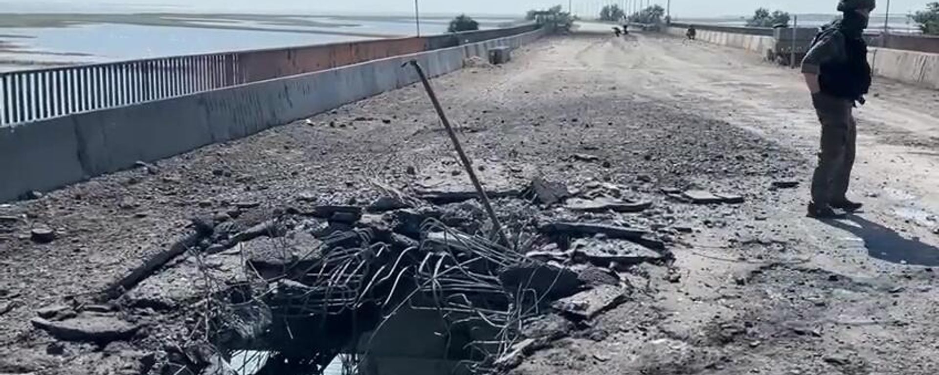 A Russian Investigative Committee serviceman stands on a bridge damaged during the Ukrainian armed forces' attack, on the administrative border between the Kherson Region and the Crimea near the village of Chongar, Crimea, Russia.  - Sputnik International, 1920, 22.06.2023