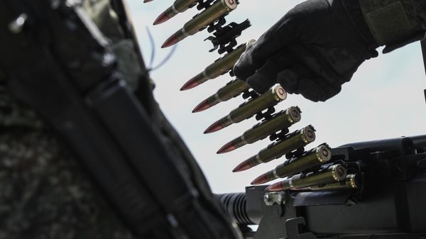 A Russian serviceman of a mobile anti-aircraft unit loads ammunition for a DShK machine gun on the back a UAZ truck - Sputnik International