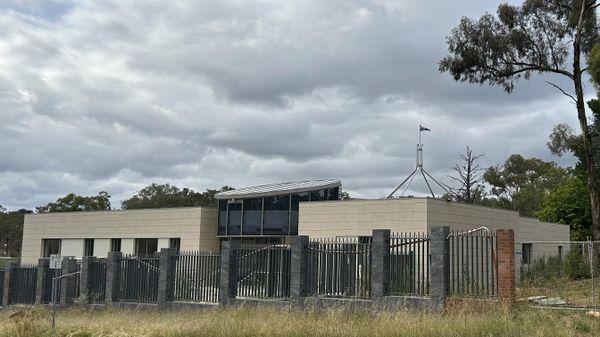 The Australian flag flies on Parliament House, seen behind an unoccupied building on the grounds of a proposed new Russian embassy near the Australian Parliament in Canberra - Sputnik International