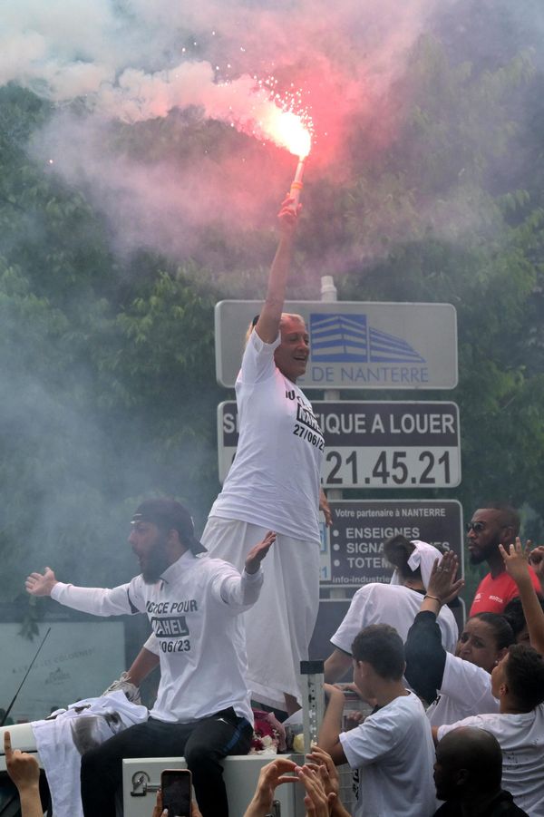 Mounia, the mother of Nahel, a teenage driver shot dead by a policeman, waves a light flare as she stands atop a truck during a commemoration march for her son. - Sputnik International