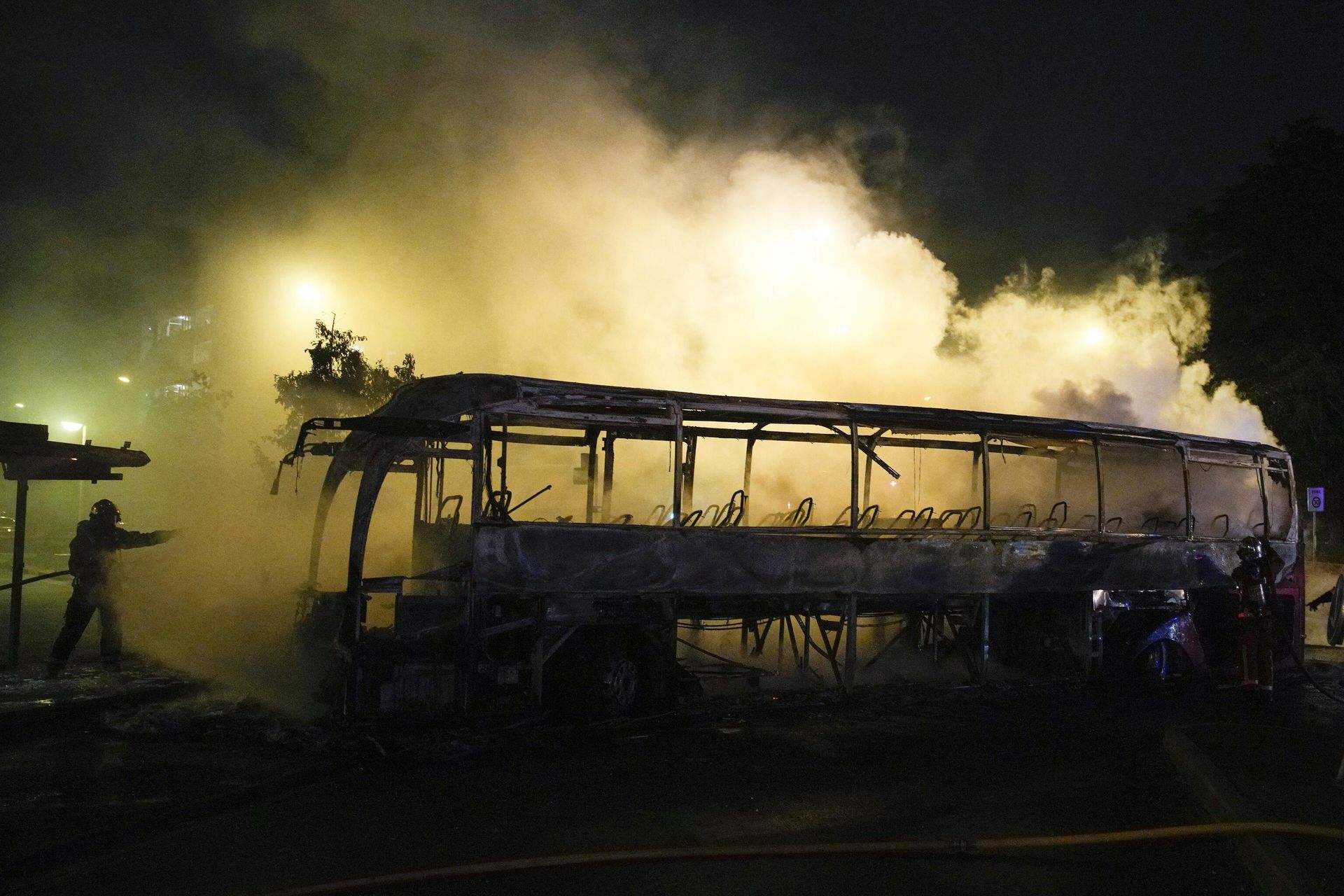 A firefighter uses a water hose on a burnt bus in Nanterre, outside Paris, France, Saturday, July 1, 2023.  - Sputnik International, 1920, 02.07.2023