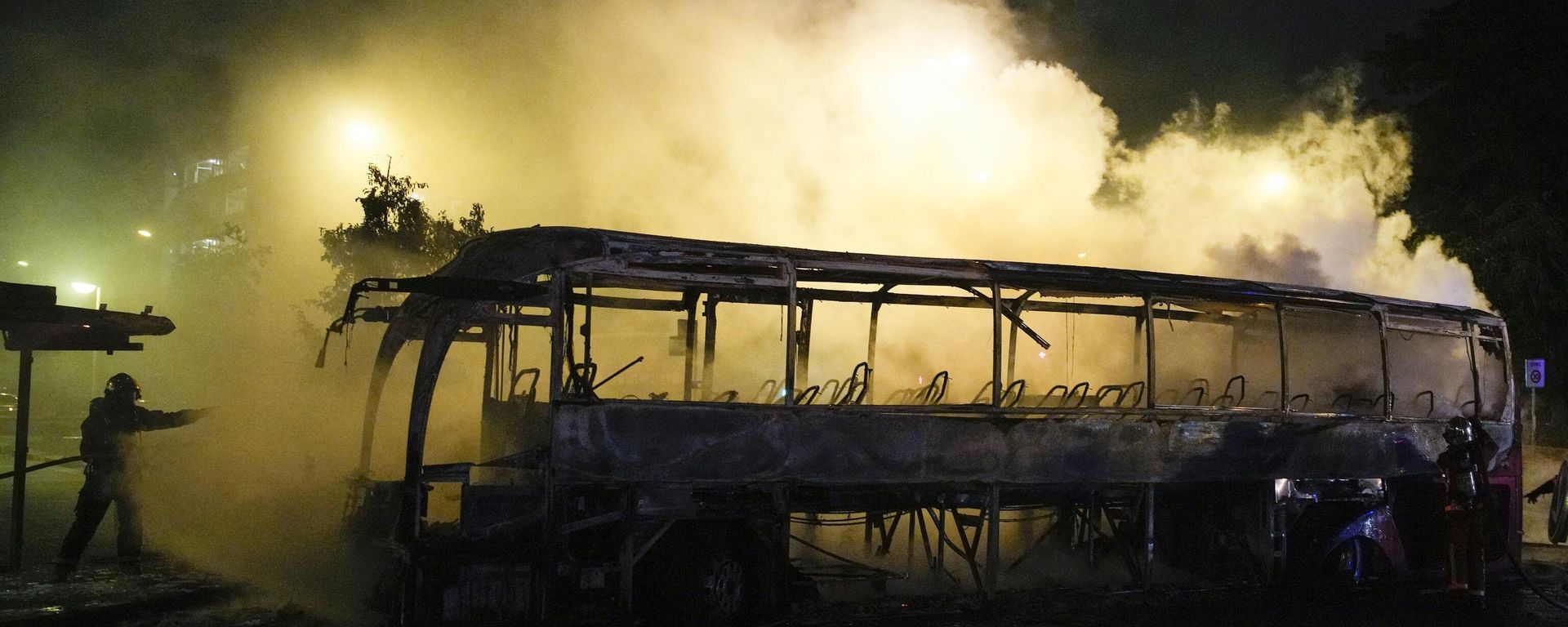 A firefighter uses a water hose on a burnt bus in Nanterre, outside Paris, France, Saturday, July 1, 2023.  - Sputnik International, 1920, 04.07.2023