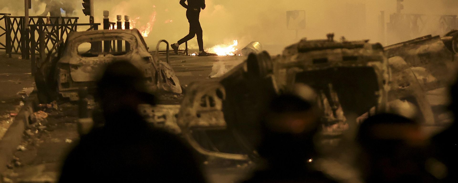A demonstrator runs on the third night of protests sparked by the fatal police shooting of a 17-year-old driver in the Paris suburb of Nanterre, France, Friday, June 30, 2023. After six years in power, French President Emmanuel Macron appears further weakened by days of rioting over the death of a teen killed by police that come on top of a series of other challenges at home, leading domestic politics to impede his influence abroad. Macron was forced to delay his state visit to Germany meant to show the strength of the friendship between both nations after recent disputes over on issues including energy, defense and the economy.  - Sputnik International, 1920, 03.07.2023