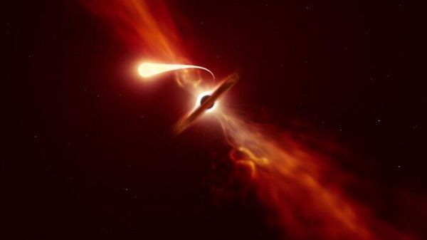 This illustration depicts a star (in the foreground) experiencing spaghettification as it’s sucked in by a supermassive black hole (in the background) during a ‘tidal disruption event’. In a new study, done with the help of ESO’s Very Large Telescope and ESO’s New Technology Telescope, a team of astronomers found that when a black hole devours a star, it can launch a powerful blast of material outwards. - Sputnik International