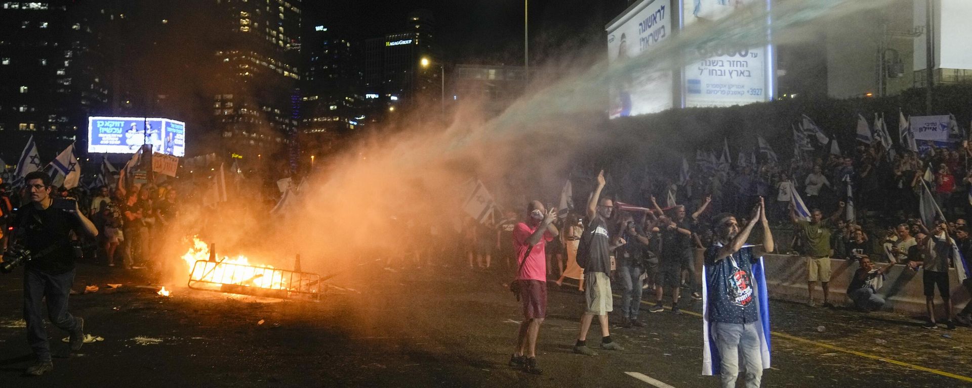 Israeli police use a water cannon to disperse demonstrators blocking the freeway during protest against plans by Prime Minister Benjamin Netanyahu's government to overhaul the judicial system in Tel Aviv, Israel, Wednesday, July 5, 2023 - Sputnik International, 1920, 03.09.2024