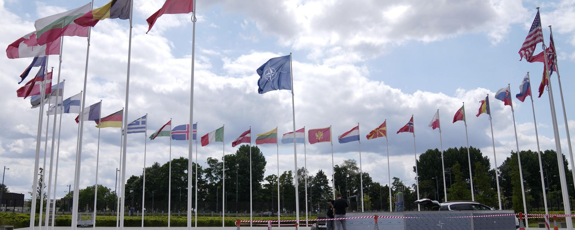Two men do construction work around the flags at NATO headquarters in Brussels, Thursday, July 6, 2023.  - Sputnik International, 1920, 10.07.2023