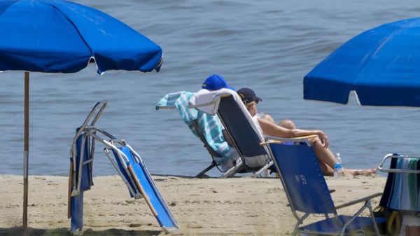 President Joe Biden, in blue hat, sits on the beach with first lady Jill Biden on Saturday, July 8, 2023, near his home in Rehoboth Beach, Del. - Sputnik International