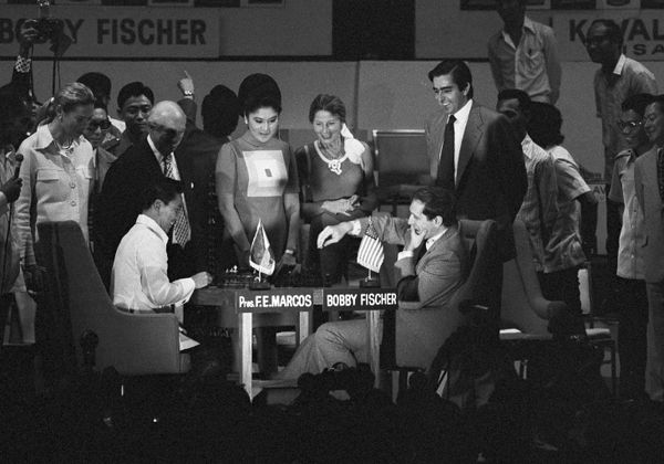 World chess champion Bobby Fischer, on the right, and Philippine President Ferdinand Marcos, on the left left, play a ceremonial game of chess during the opening of the Philippines International Chess Tournament in M anila, October 16, 1973. In the background are the president's wife Imelda and Christina Ford. - Sputnik International