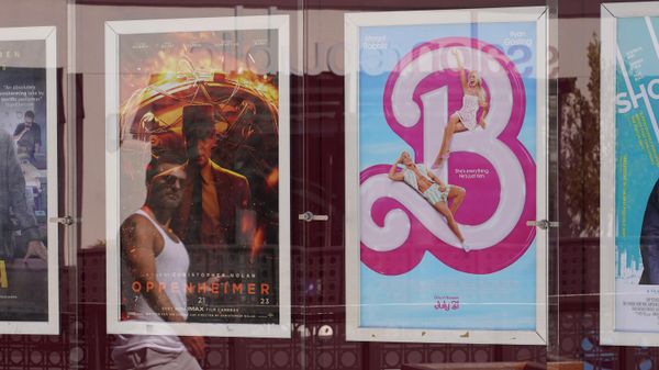 A man's reflection appears walking past advertisements for the films Oppenheimer, from left, and Barbie, on Thursday, July 20, 2023, at the Landmark Theater in Los Angeles.  - Sputnik International