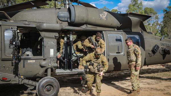Sgt. Louis Ortiz, 16th Combat Aviation Brigade, Task Force Warhawk, Battle Group Griffin, evaluates Soldiers from the Australian Defence Force (ADF) as they exit an UH-60 Black Hawk assigned to 16th CAB during hot/cold loading training, as a part of Exercise Talisman saber in an ADF training area outside of Townsville, Queensland, Australia, July 22, 2023. - Sputnik International