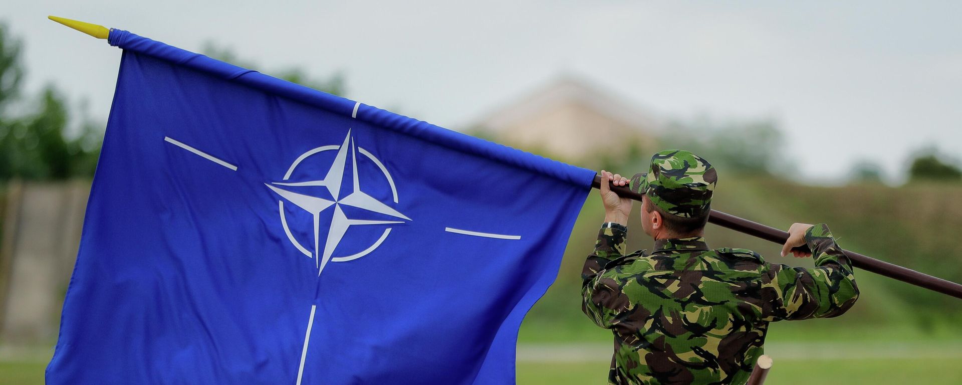 A Romanian serviceman furls the NATO flag. File photo A Romanian serviceman furls the NATO flag. File photo - Sputnik International, 1920, 20.12.2023