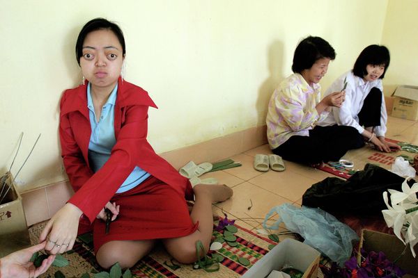 Nguyen Thi Van Long, 19, left, from Nam Dinh province makes paper flowers with her classmates at the Vietnam Friendship Village for children and veterans suffering the effects of Agent Orange on the outskirts of Hanoi, Vietnam. - Sputnik International