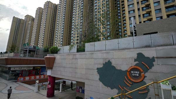 A man walks by a China's map showing Evergrande development projects and its apartment buildings are seen behind, at an Evergrande city plaza in Beijing. File photo. - Sputnik International