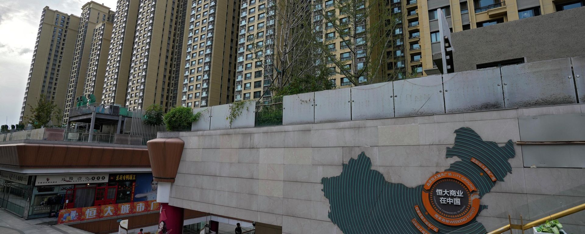 A man walks by a China's map showing Evergrande development projects and its apartment buildings are seen behind, at an Evergrande city plaza in Beijing. File photo. A man walks by a China's map showing Evergrande development projects and its apartment buildings are seen behind, at an Evergrande city plaza in Beijing. File photo. - Sputnik International, 1920, 29.01.2024