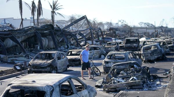 A man walks through wildfire wreckage Friday, Aug. 11, 2023, in Lahaina, Hawaii - Sputnik International