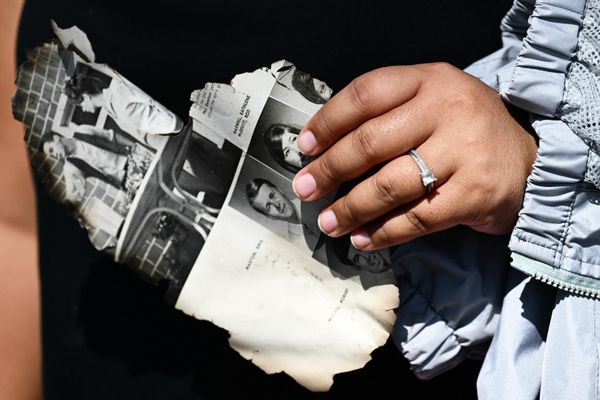 A woman holds a page of a yearbook as she looks for belongings through the ashes of their family’s home, destroyed by the devastating Hawaii wildfires. - Sputnik International