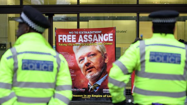 A police officer stands in front of the banner with a photo of Julian Assange near the Westminster Magistrates' Court in London - Sputnik International