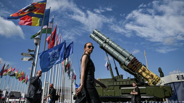 A participant walks past a multiple launch rocket system during the Army 2023 International Military Technical Forum at the Patriot Congress and Exhibition Centre in Moscow region, Russia. - Sputnik International