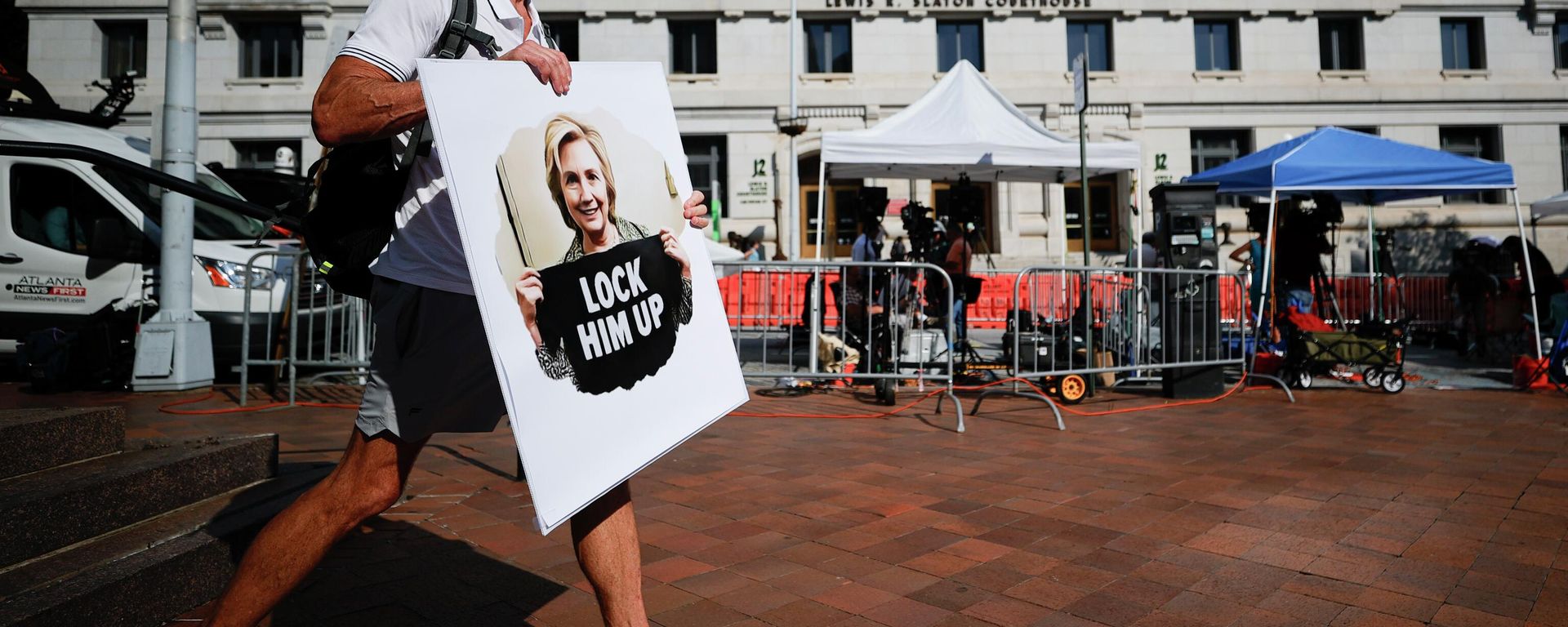 A person holding a sign that reads Lock Him Up, stands outside of the Fulton County Courthouse, Monday, Aug. 14, 2023, in Atlanta. Court officials in Atlanta published a list of criminal charges against former President Donald Trump. But as a Fulton County grand jury began hearing from witnesses Monday, there was no public indication that Trump had been indicted in a long-running investigation of the 2020 presidential election. The list was later deleted. A person holding a sign that reads Lock Him Up, stands outside of the Fulton County Courthouse, Monday, Aug. 14, 2023, in Atlanta. Court officials in Atlanta published a list of criminal charges against former President Donald Trump. But as a Fulton County grand jury began hearing from witnesses Monday, there was no public indication that Trump had been indicted in a long-running investigation of the 2020 presidential election. The list was later deleted. - Sputnik International, 1920, 16.08.2023