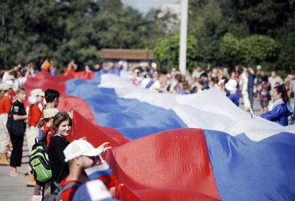 Participants in celebrations marking Russian Flag Day unfurl a 100-metre-long Russian flag on Lenin Square in Mariupol. - Sputnik International