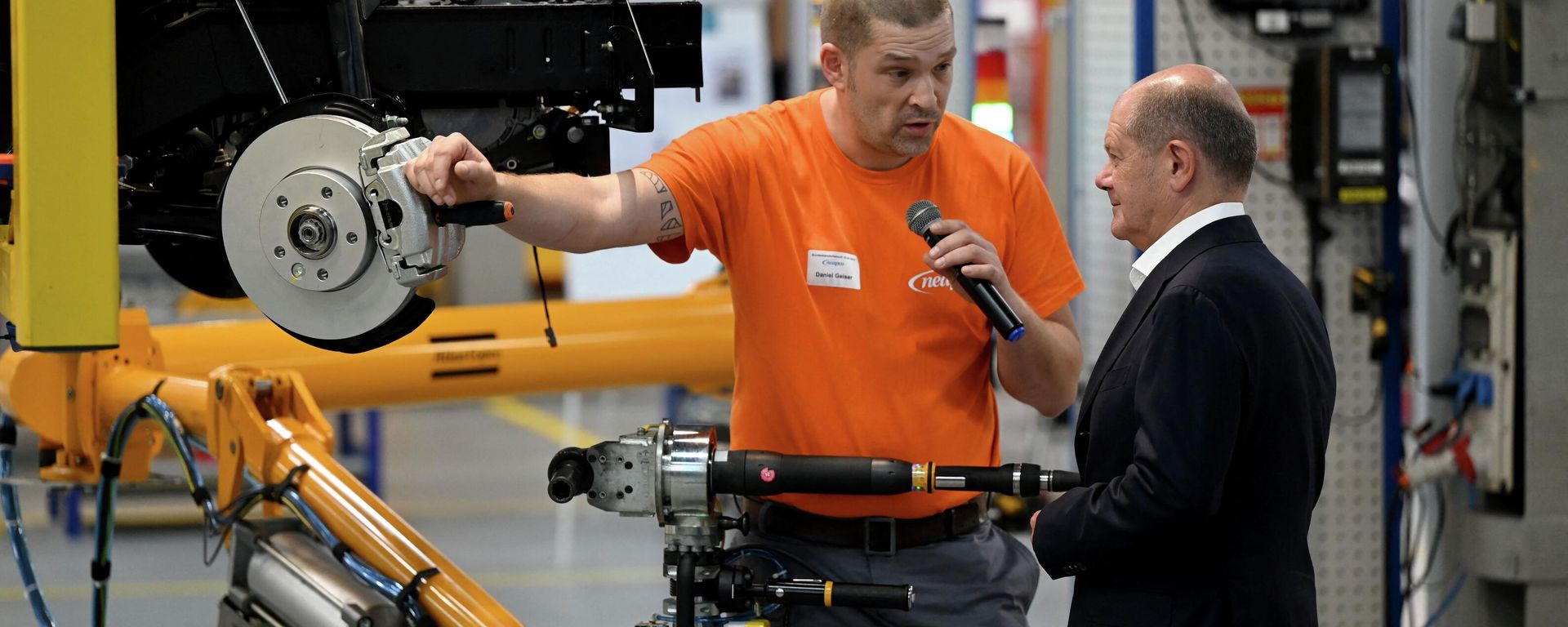German Chancellor Olaf Scholz (R) talks with an employee who works on the assembling of a brake caliper for an electric vehicle during a visit at the plant of Neapco Europe in Duren, western Germany, on August 22, 2023. German Chancellor Olaf Scholz (R) talks with an employee who works on the assembling of a brake caliper for an electric vehicle during a visit at the plant of Neapco Europe in Duren, western Germany, on August 22, 2023. - Sputnik International, 1920, 19.09.2023