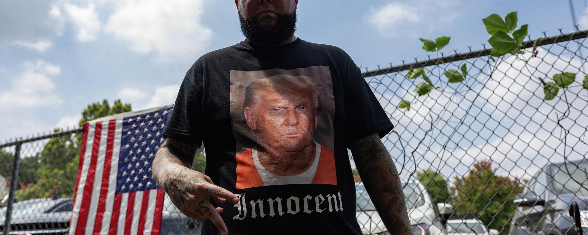 A supporter of former President Donald Trump wears a shirt proclaiming his innocence while waiting for him to arrive outside the Fulton County Jail on August 24, 2023, in Atlanta, Georgia. A supporter of former President Donald Trump wears a shirt proclaiming his innocence while waiting for him to arrive outside the Fulton County Jail on August 24, 2023, in Atlanta, Georgia. - Sputnik International, 1920, 27.08.2023