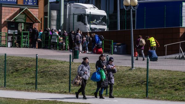 People queue to cross the border on their way back to Ukraine (back) as refugees from Ukraine are seen arriving in Poland (front) at the border crossing in Medyka, southeastern Poland on April 8, 2022. - Sputnik International